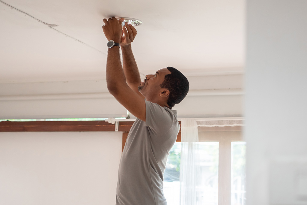 Man adjusting light in ceiling