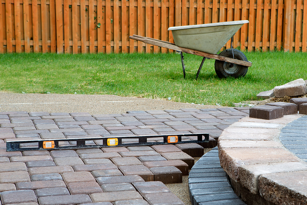 Construction on an outdoor patio with a wheelbarrow and bricks