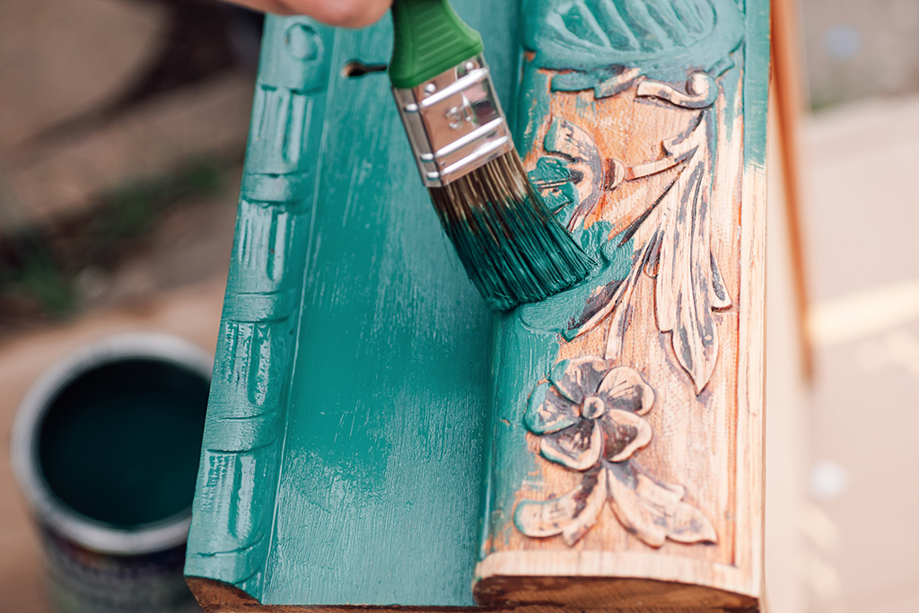 Paintbrush painting wood a teal color