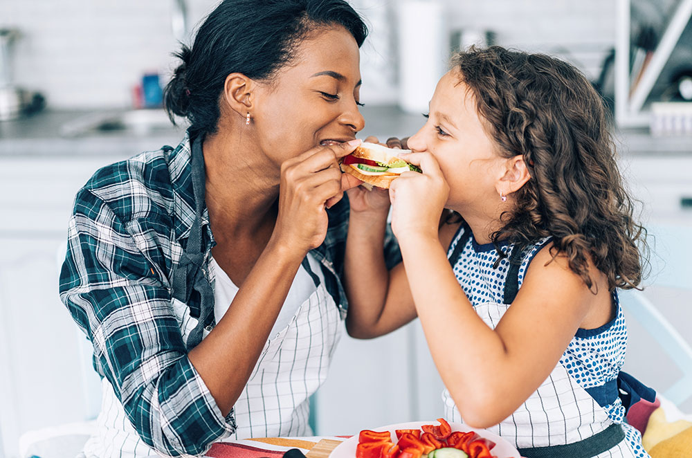 Mom and daughter sharing a sandwich