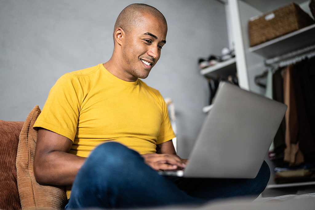 Man sitting on couch with laptop computer