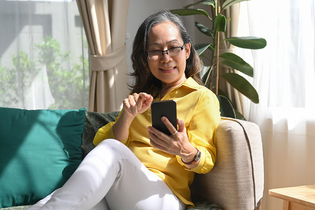 Woman sitting on couch on her phone