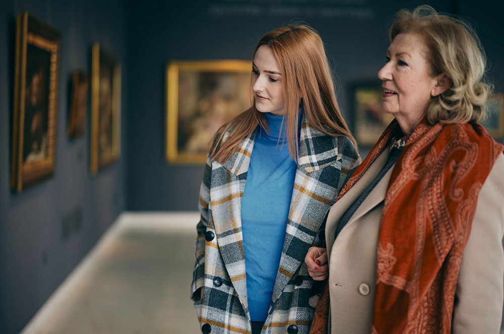 Grandma and granddaughter looking at art in museum