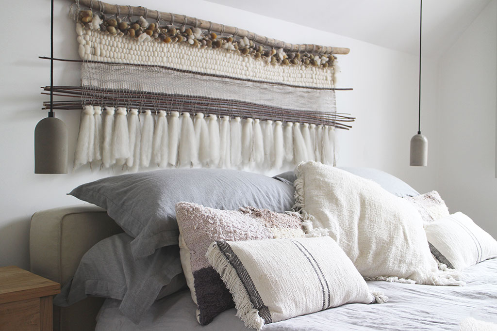 Boho bed with macrame wall tapestry on wall above bed