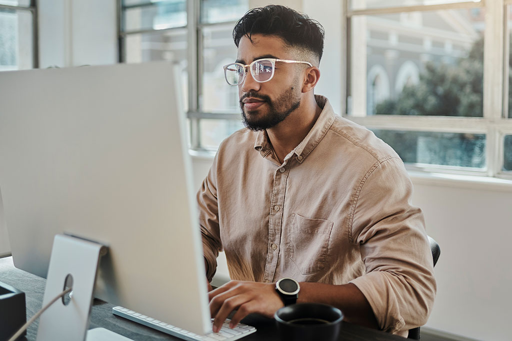 Younger man at work on computer