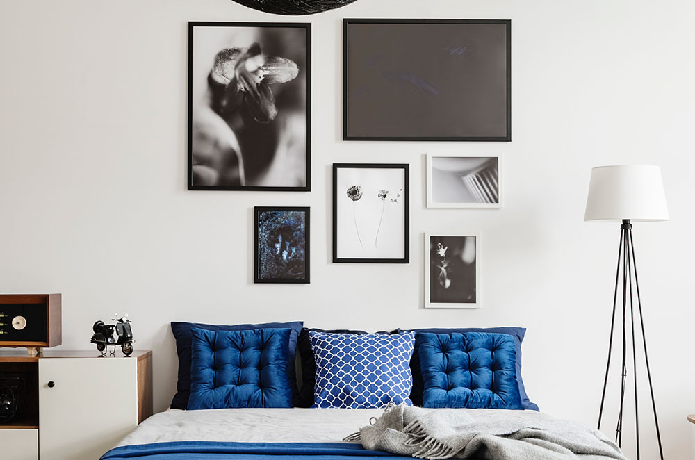 Frames with pictures above bed in bedroom