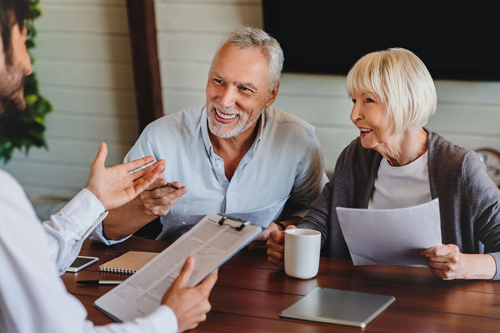 Older couple sitting across table from advisor