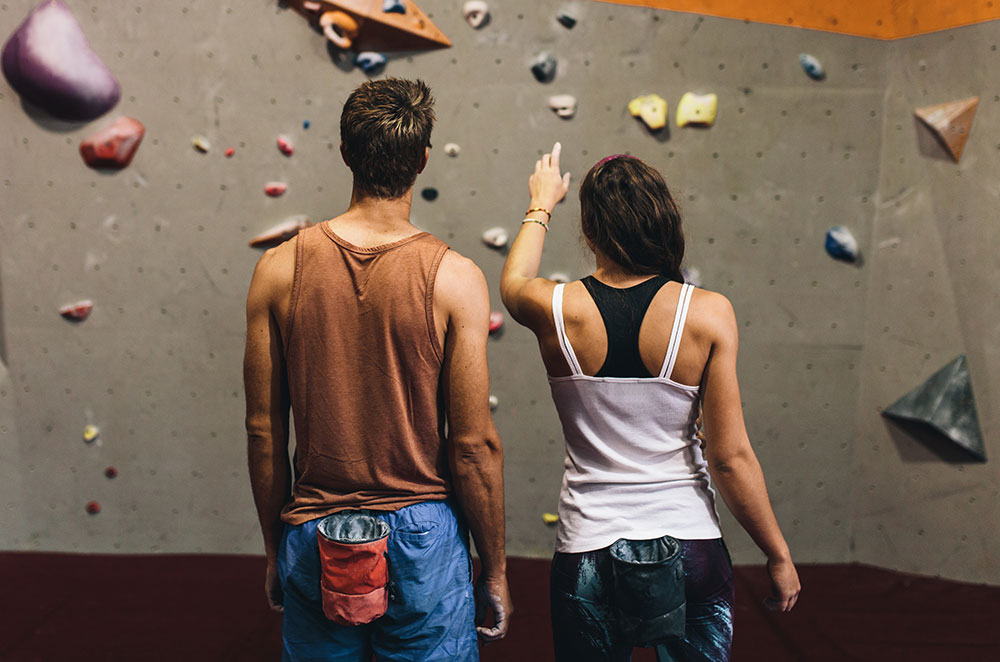 Guy and girl about to rock climb indoor