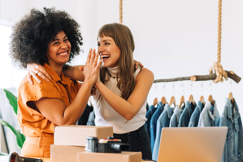 Business owners of boutique giving each other a high-five