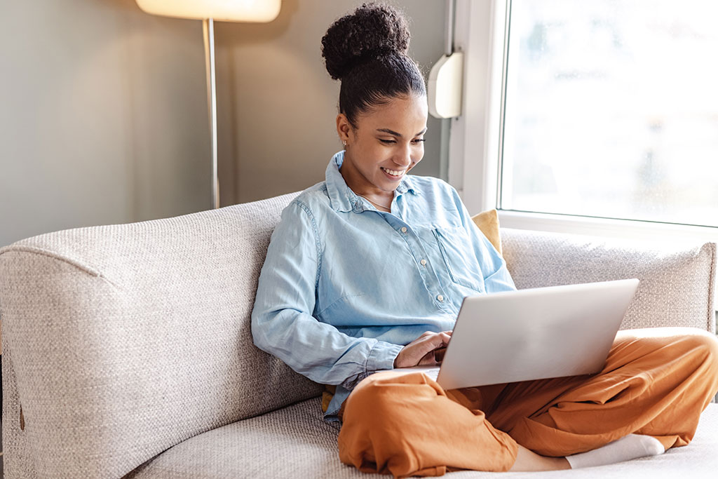 Woman sitting on couch on laptop