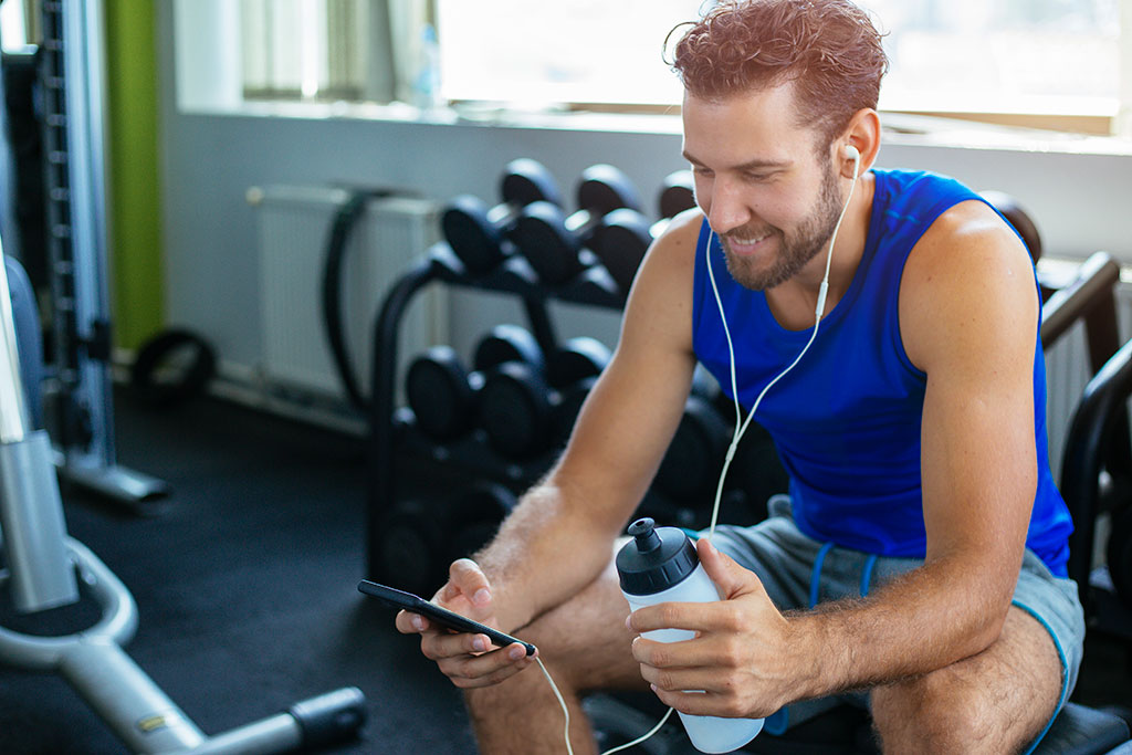 Man at gym listening to podcast