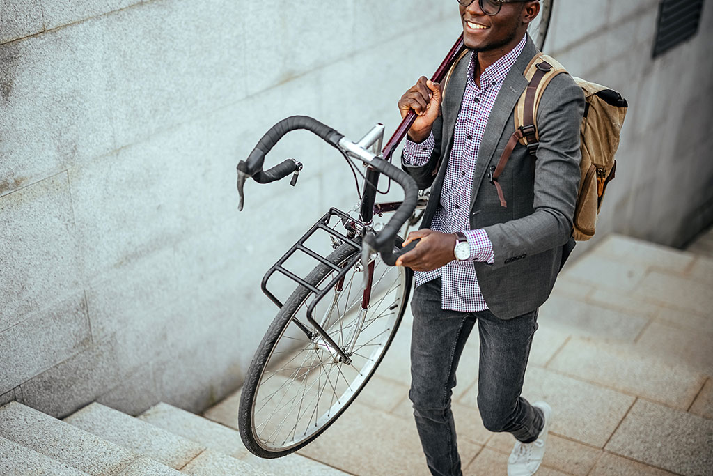 Man carrying bike upstairs to work