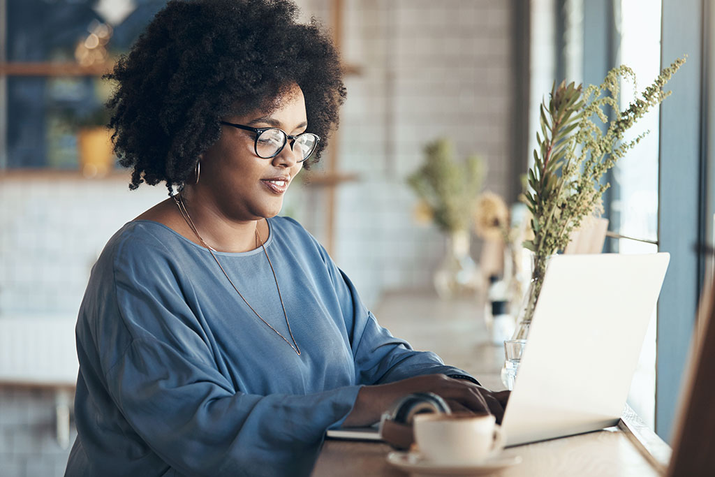 Woman using laptop at coffee shop