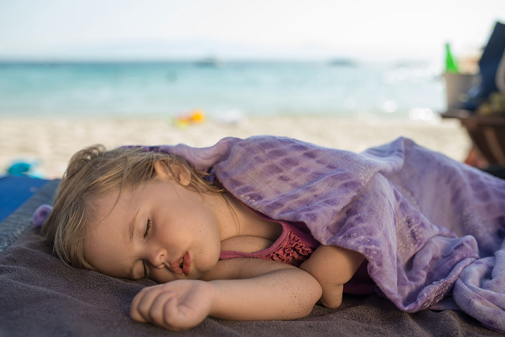 Little kid sleeping on at beach