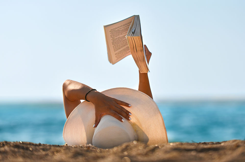 Woman reading book on beach