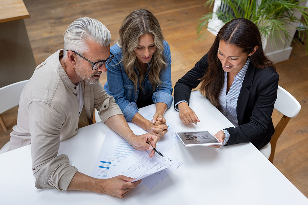 Couple talking with real estate agent looking over documents