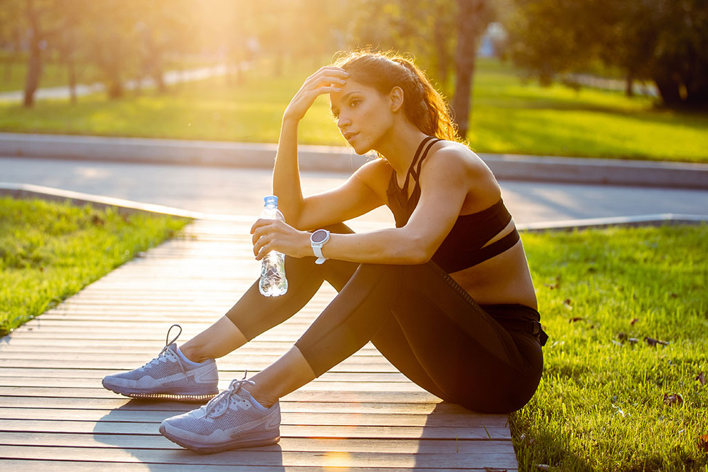 Woman sitting down after run with water