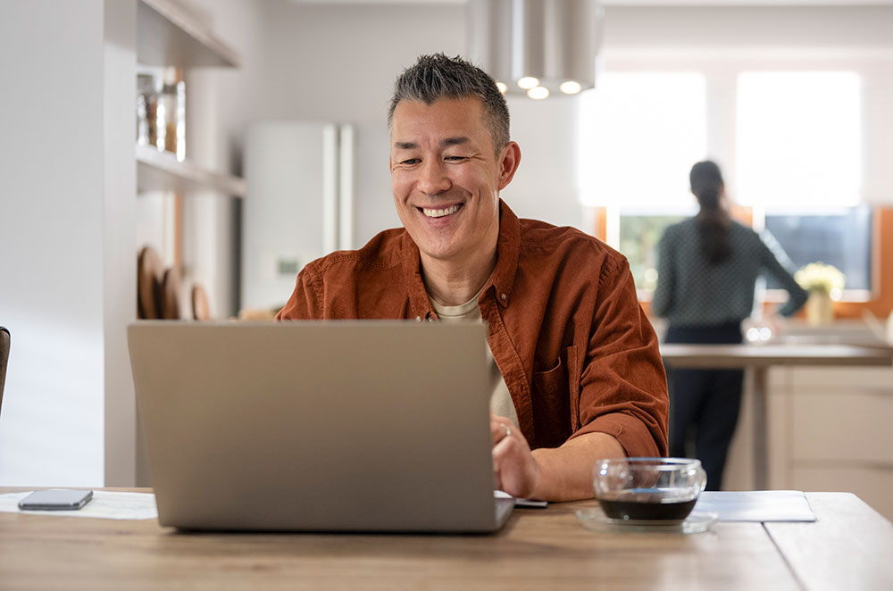 Man on laptop in kitchen