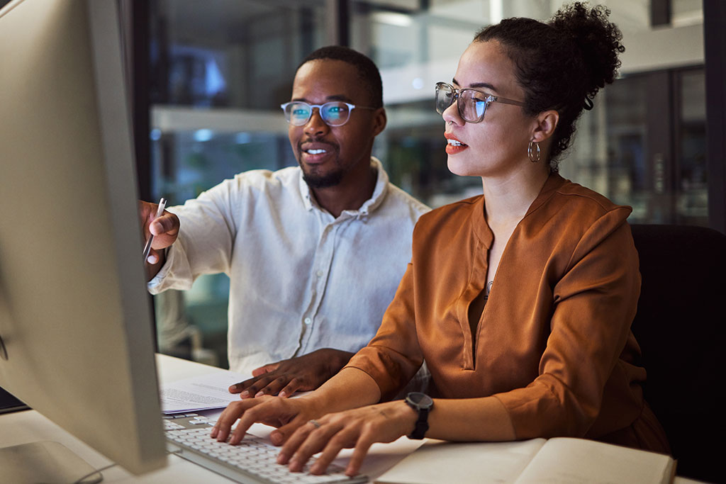 Co-workers looking at desktop computer