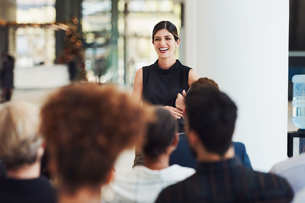 People listening to business woman speaking