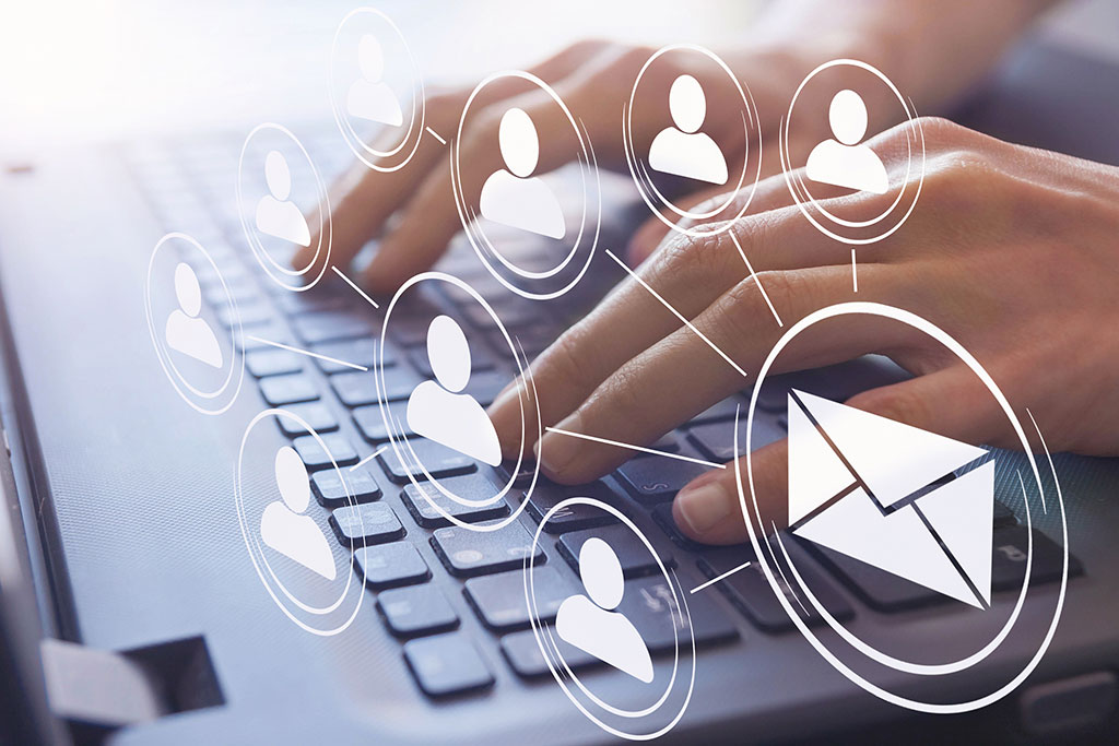 Sending email out to clients graphic above laptop
