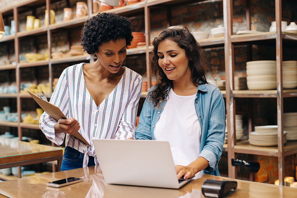 Women business owners looking at laptop