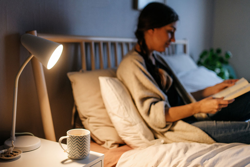 Woman reading book before bed