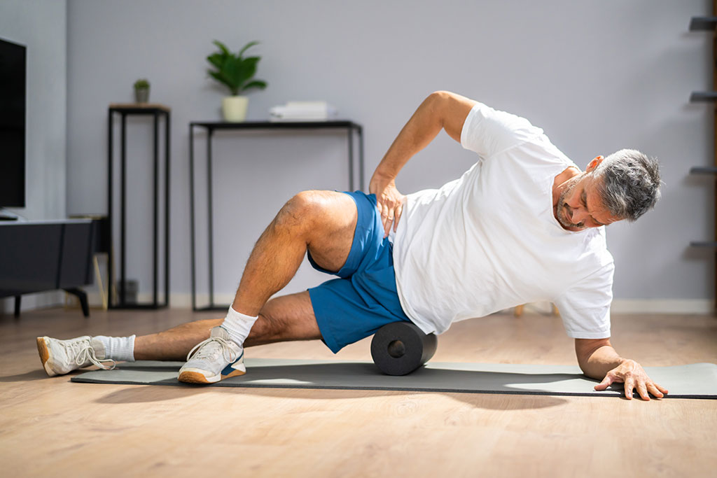 Man using foam roller on muscles