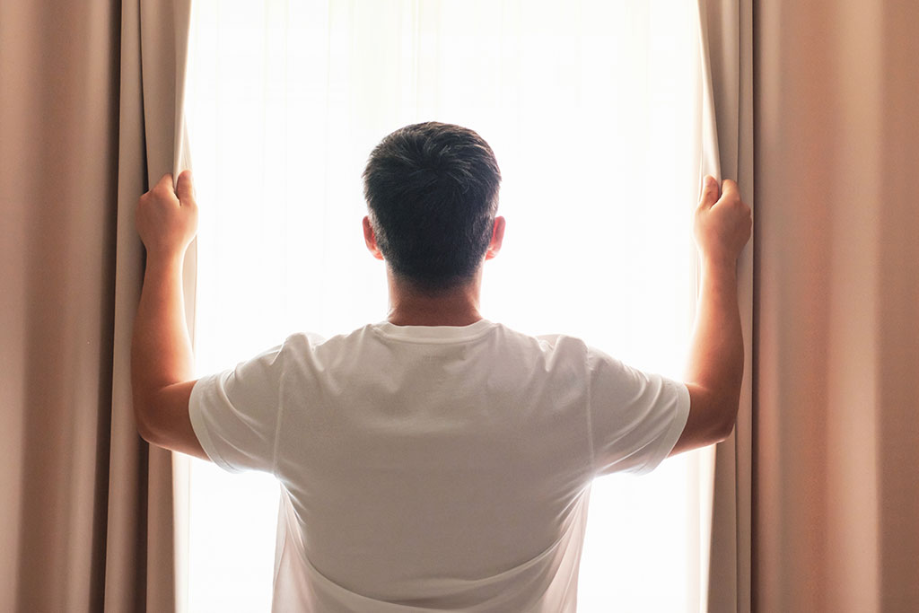 Man opening blinds