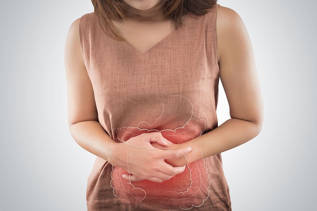 Woman holding stomach with graphic of stomach outline