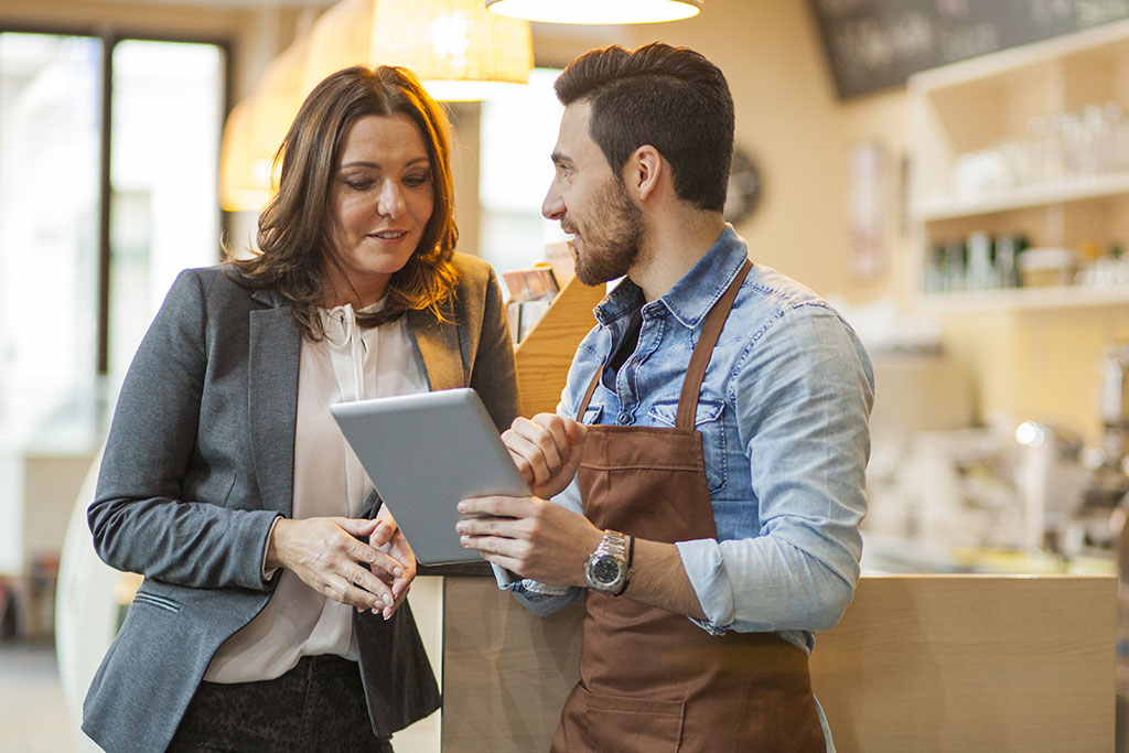 Small business owners looking at tablet