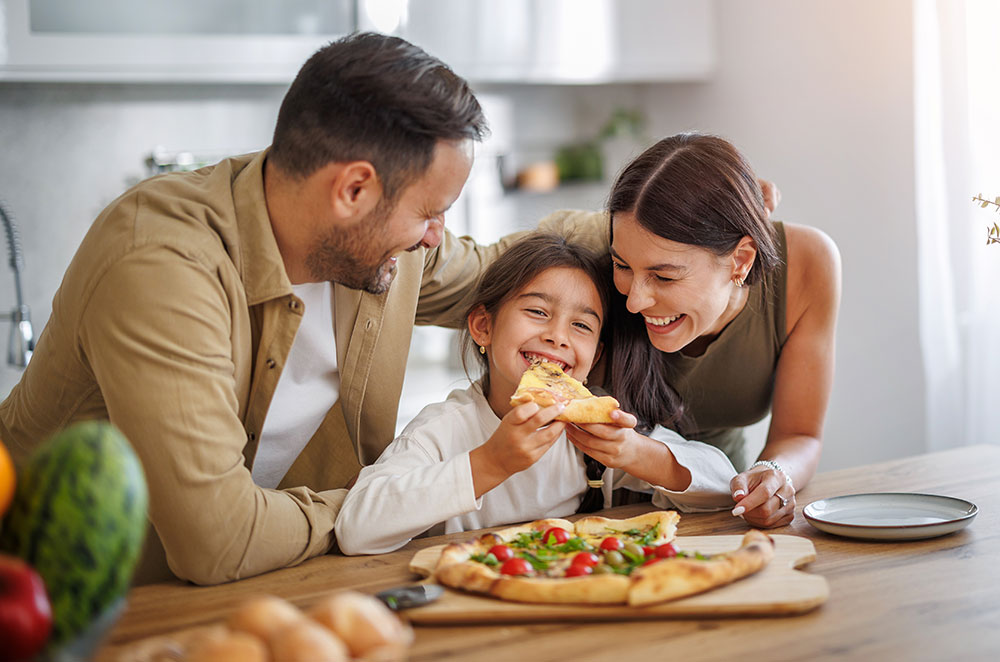 Family eating pizza in kitchen