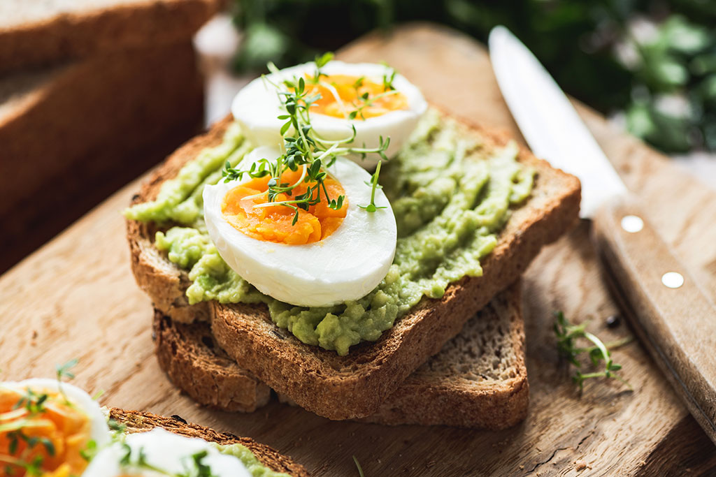 Avocado toast with boiled egg on top cut in half