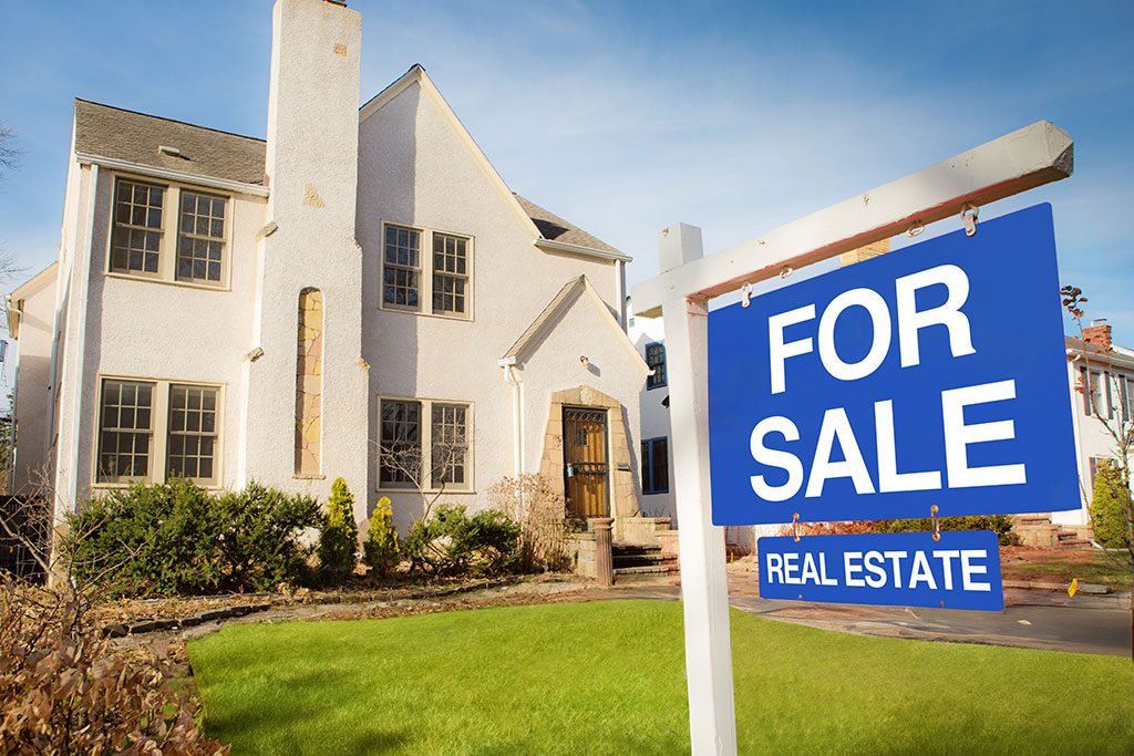 House for sale sign in front of older house