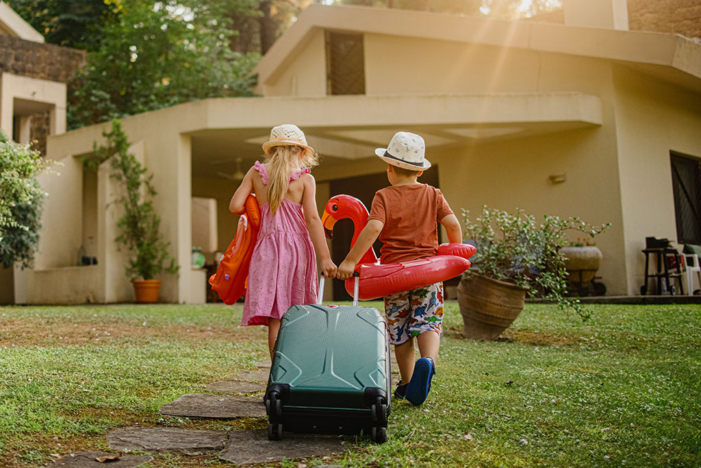 Kids on vacation walking into rental vacation home